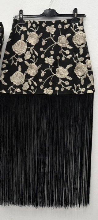 Falda negra con bordado floral y flecos