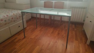 Mesa de patas metálicas y sobre de cristal