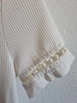Top Bershka blanco con perlas en las mangas.