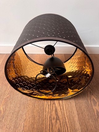 Lámpara de techo negra con interior dorado oscuro.