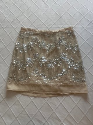 Falda corta beige con lentejuelas plateadas
