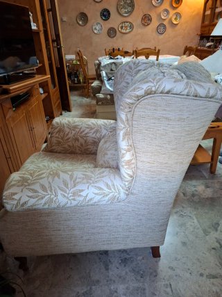 Dos sillones orejeros beige , con fino estampado.