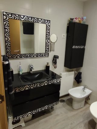 Muebles de baño negros y plateados y el espejo