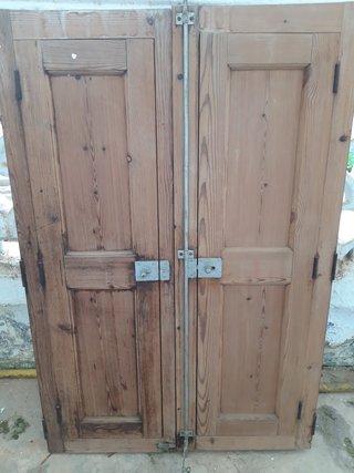 Ventana vidriera con portones de madera