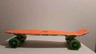 Patinete naranja con ruedas verdes