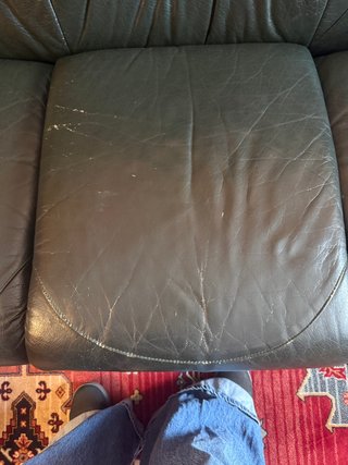 Sofá de piel verde con detalles de madera