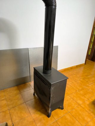 Estufa de leña negra con puerta de cristal