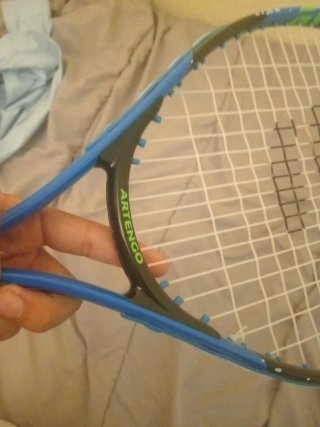 Raqueta de tenis de niño azul con funda negra.
