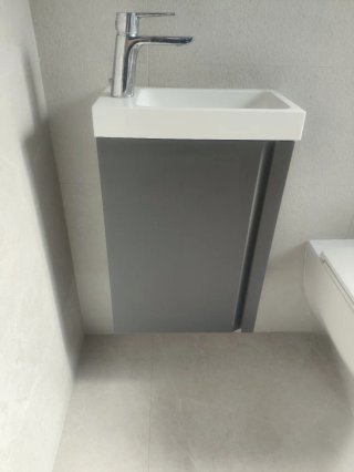 Mueble de baño con lavabo blanco, sin grifo.