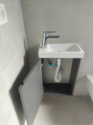 Mueble de baño con lavabo blanco, sin grifo.