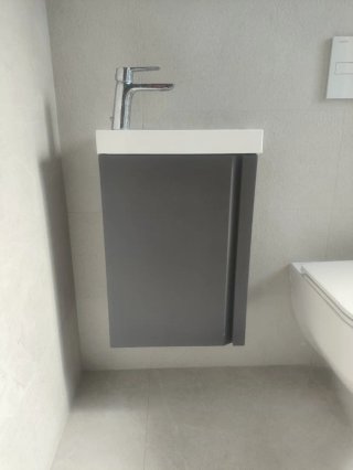 Mueble de baño con lavabo blanco, sin grifo.