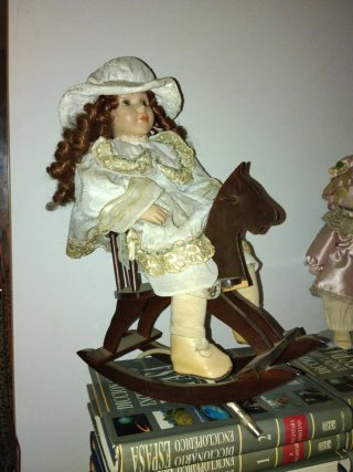 Muñeca de porcelana antigua montada en caballito