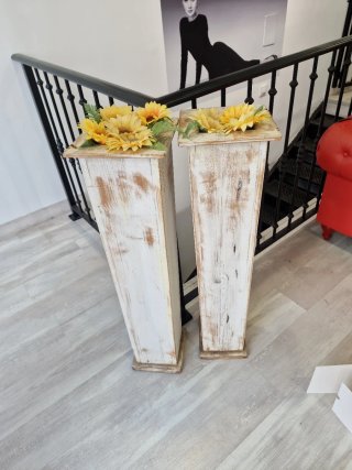 Maceteros de madera blancos con flores amarillas