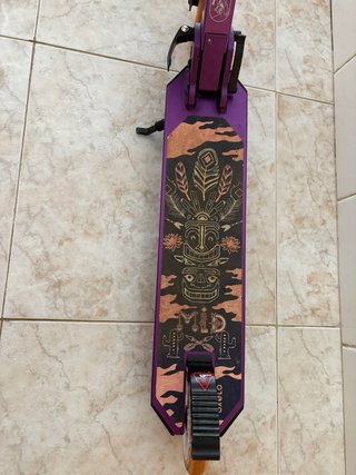 Patinete morado con ruedas naranjas