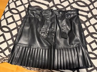 Falda de cuero negra con cinturón y plisados