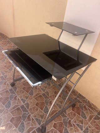 Scrivania in vetro scuro con ruote
