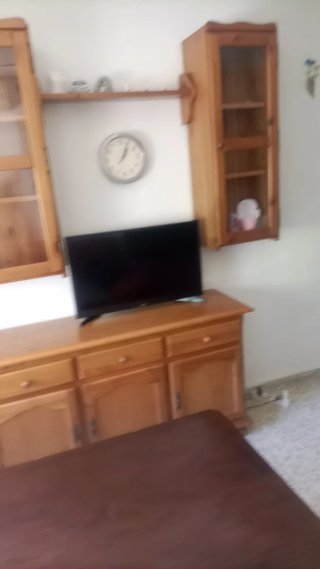Mueble de salón de madera con puertas de cristal