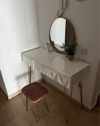 Tocador blanco con silla y espejo.