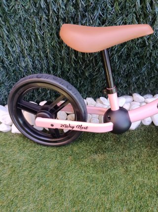 Bicicleta sin pedales rosa Kinderkraft y casco