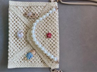 Pochette a busta in rafia intrecciata color avorio