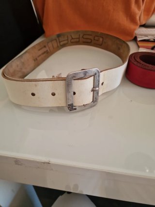 Cinturón blanco con hebilla metálica