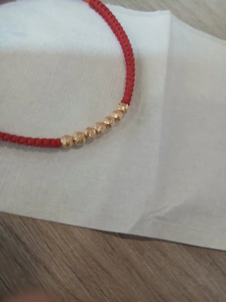 Pulsera roja con elementos de ORO colombiano.