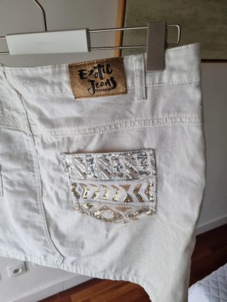 Falda corta desigual blanca con detalles dorados