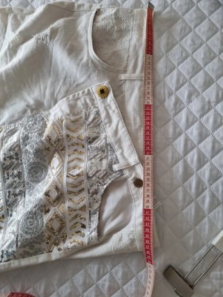 Falda corta desigual blanca con detalles dorados
