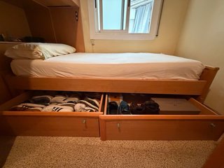 Litera de madera con cajones y colchones.