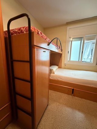 Litera de madera con cajones y colchones.