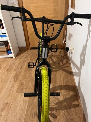Bicicleta BMX plateada con ruedas amarillas