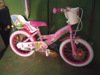 Bicicleta infantil rosa con cesta. Tiene ruedines.