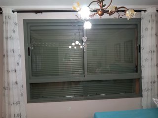 Ventana de balcón con persianas