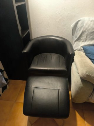 Poltrona in pelle nera con pouf per poggiapiedi