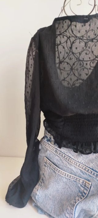 Camisa negra con volantes y manga larga