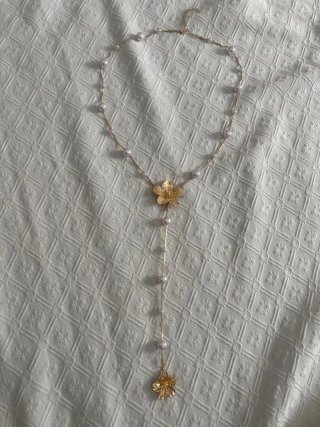 Collar dorado con perlas y flor
