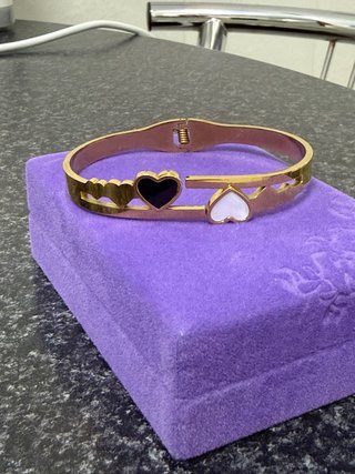 Pulsera rígida dorada con corazones