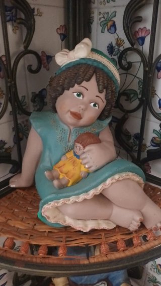 Figura de niña con muñeca