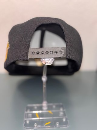 Gorra urbana negra con logo dorado