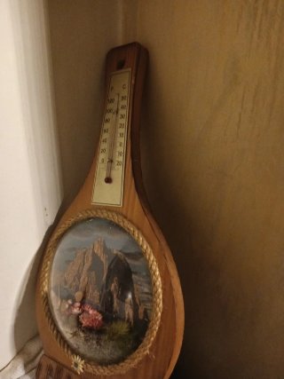 Termometro in legno con paesaggio montagne