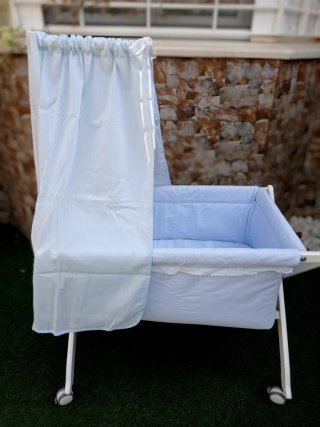 Minicuna madera blanca con ropa celeste y dosel