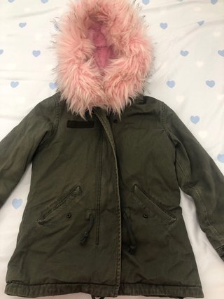 Chaqueta niña verde con capucha rosa de pelo.