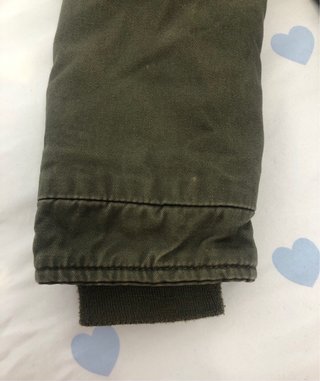 Chaqueta niña verde con capucha rosa de pelo.