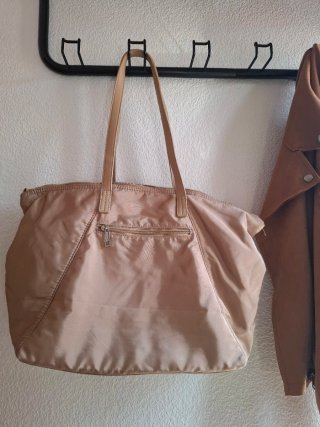 Bolso de mano beige.