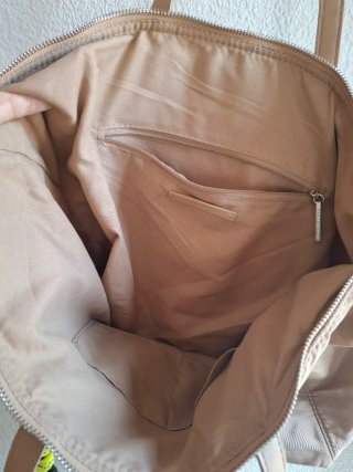 Bolso de mano beige.