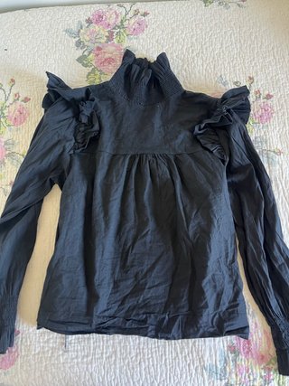 Blusa negra con volantes y cuello alto