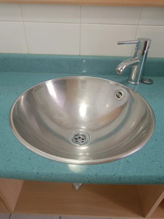 Espejo baño con lavabo metálico y mueble madera