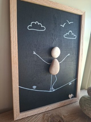 Quadro sassi equilibrista su tavola legno
