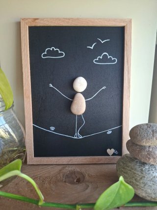 Quadro sassi equilibrista su tavola legno