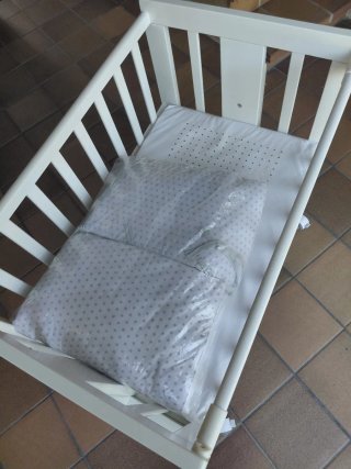 Minicuna blanca con ruedas.
